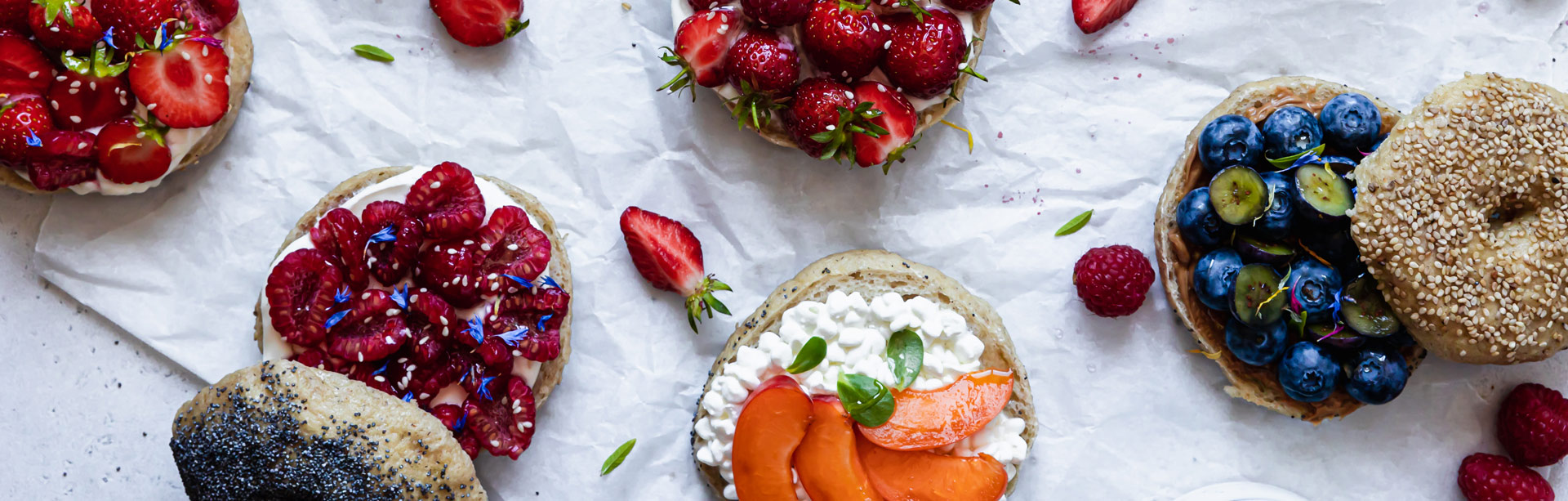 Bagels sans gluten garnis de fromage blanc, fruits rouges et autres baies