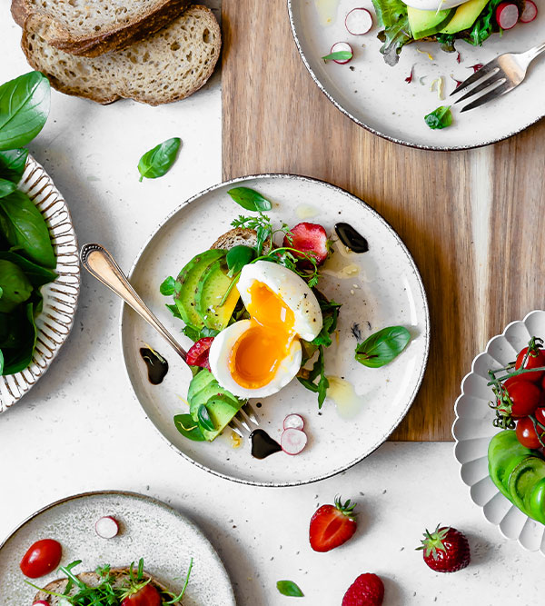 Un avocado toast fait avec du pain sans gluten Piaf avec un oeuf mollet au jaune coulant sur le dessus